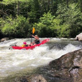 woman and child rafting along the waves on the Chattooga River in Long Creek South Carolina