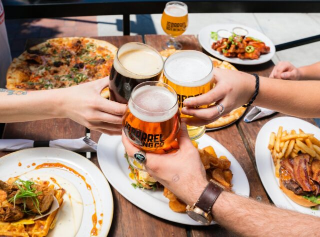 three friends clank beer glasses before their meals at Humble Pie in Long Creek South Carolina